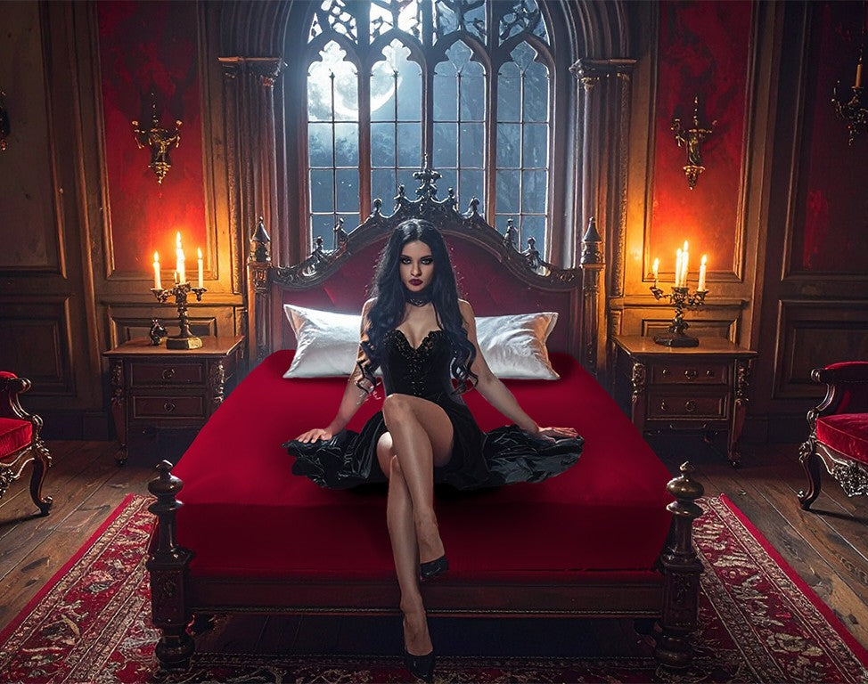 Red jersey-knit stretch fitted sheet on an extra-deep mattress — gothic woman in black dress sits in a moonlit castle bedroom.